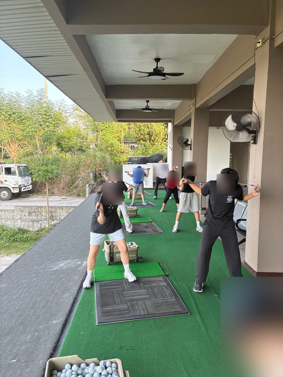 Group lesson in progress at the driving range near Talk Academy