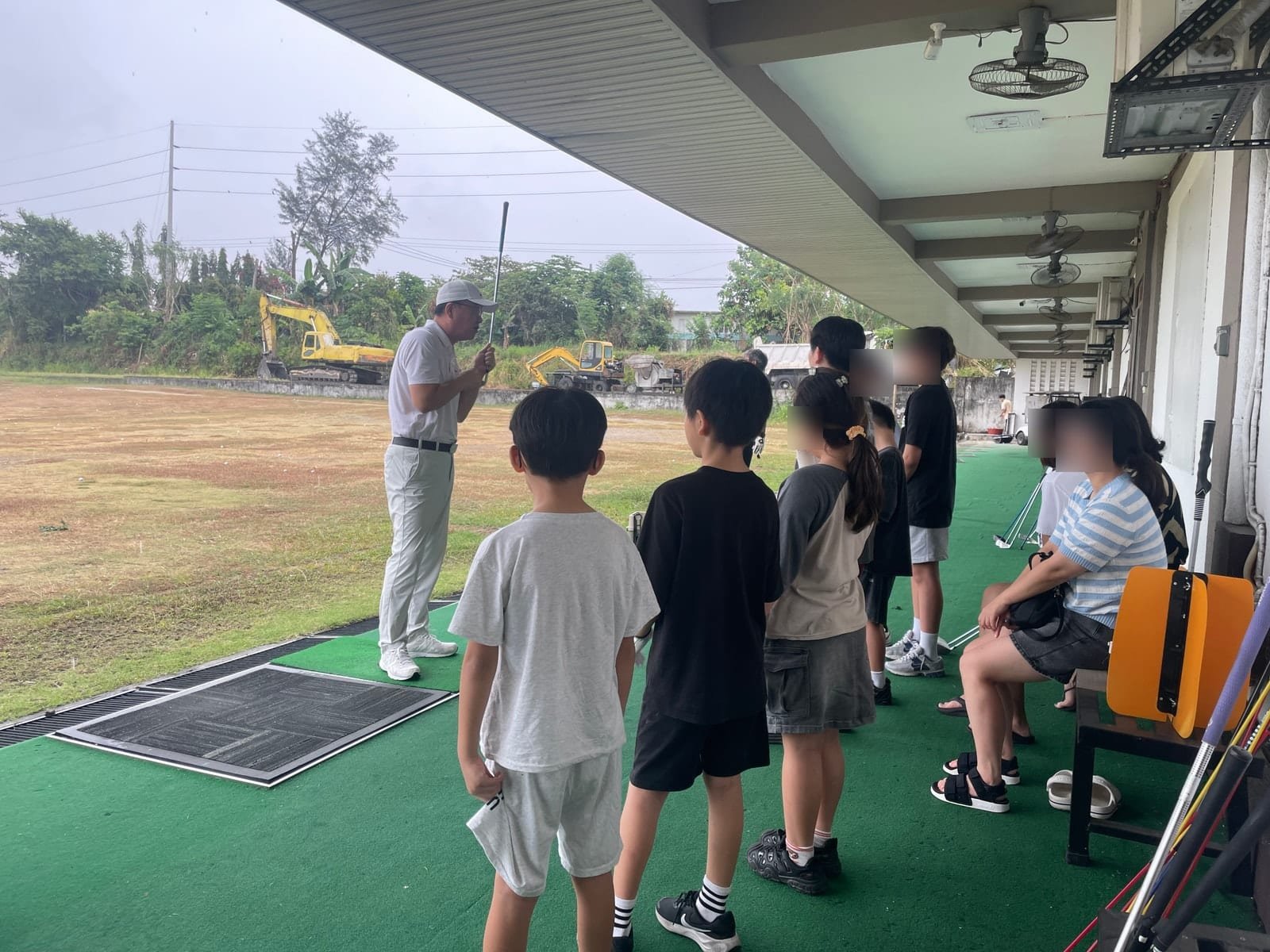 Certified teaching pro giving a group golf lesson to Talk Academy students