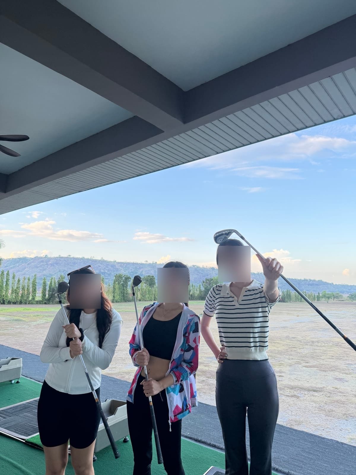 Students with clubs at the driving range before a lesson