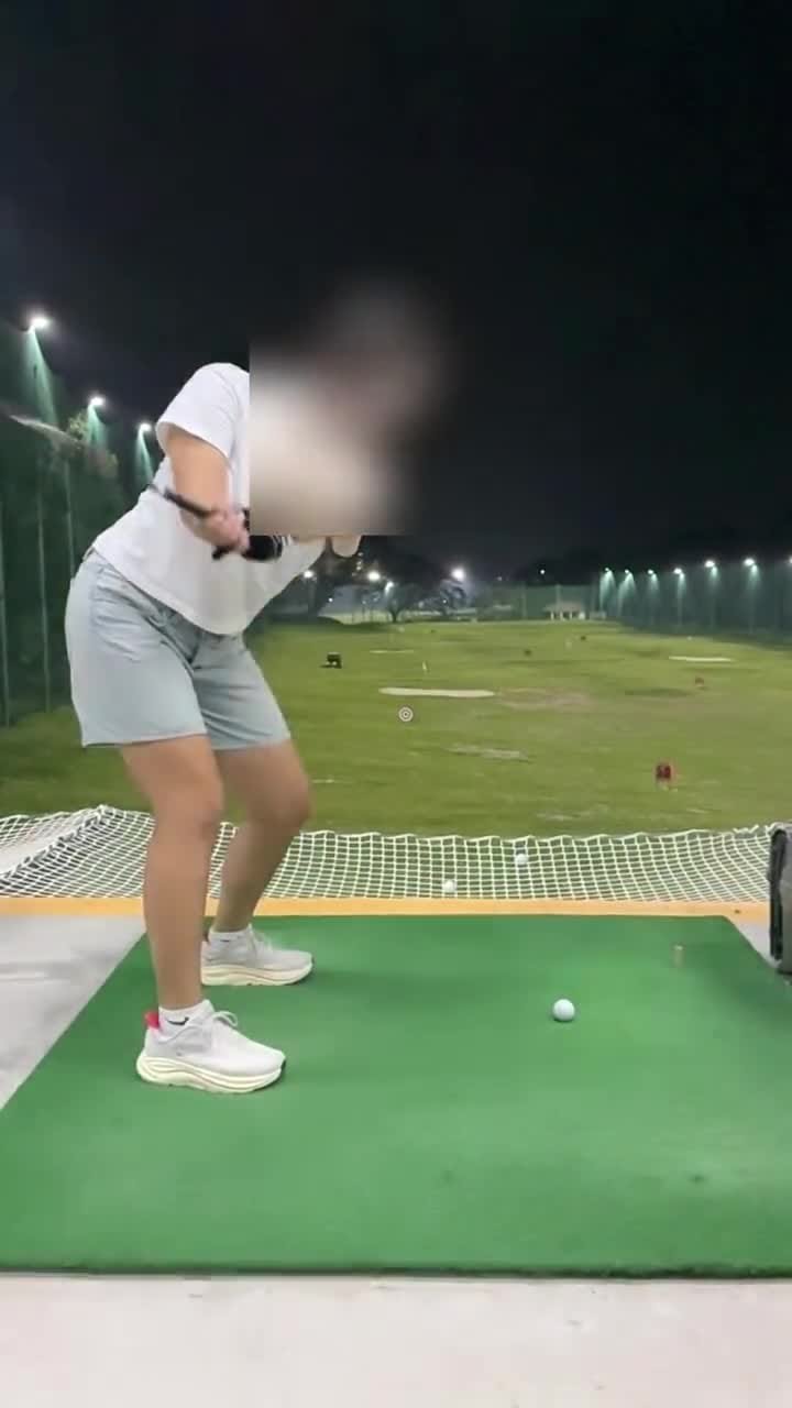 Evening driving-range lesson under the floodlights