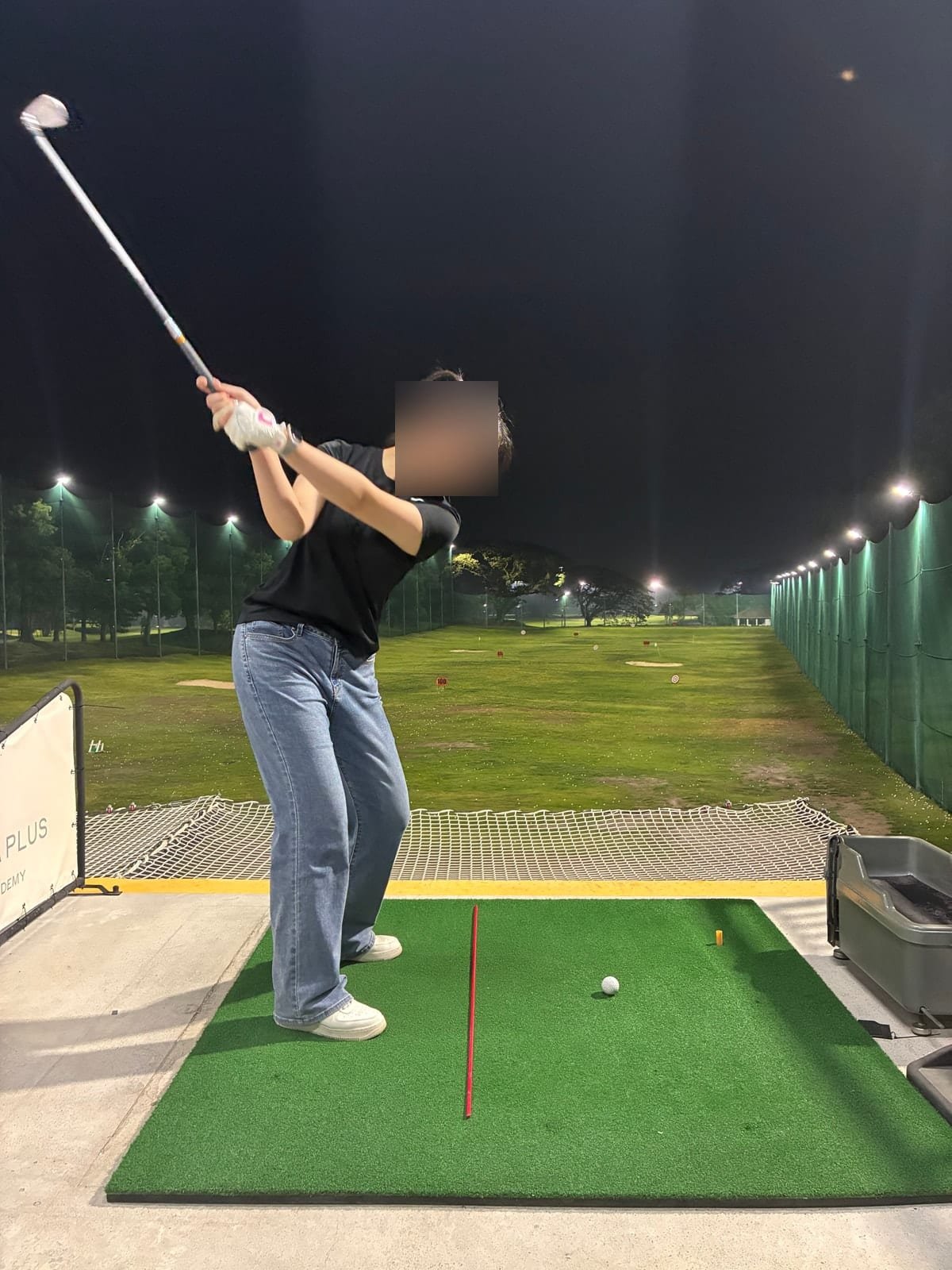 Student mid-swing during an evening lesson