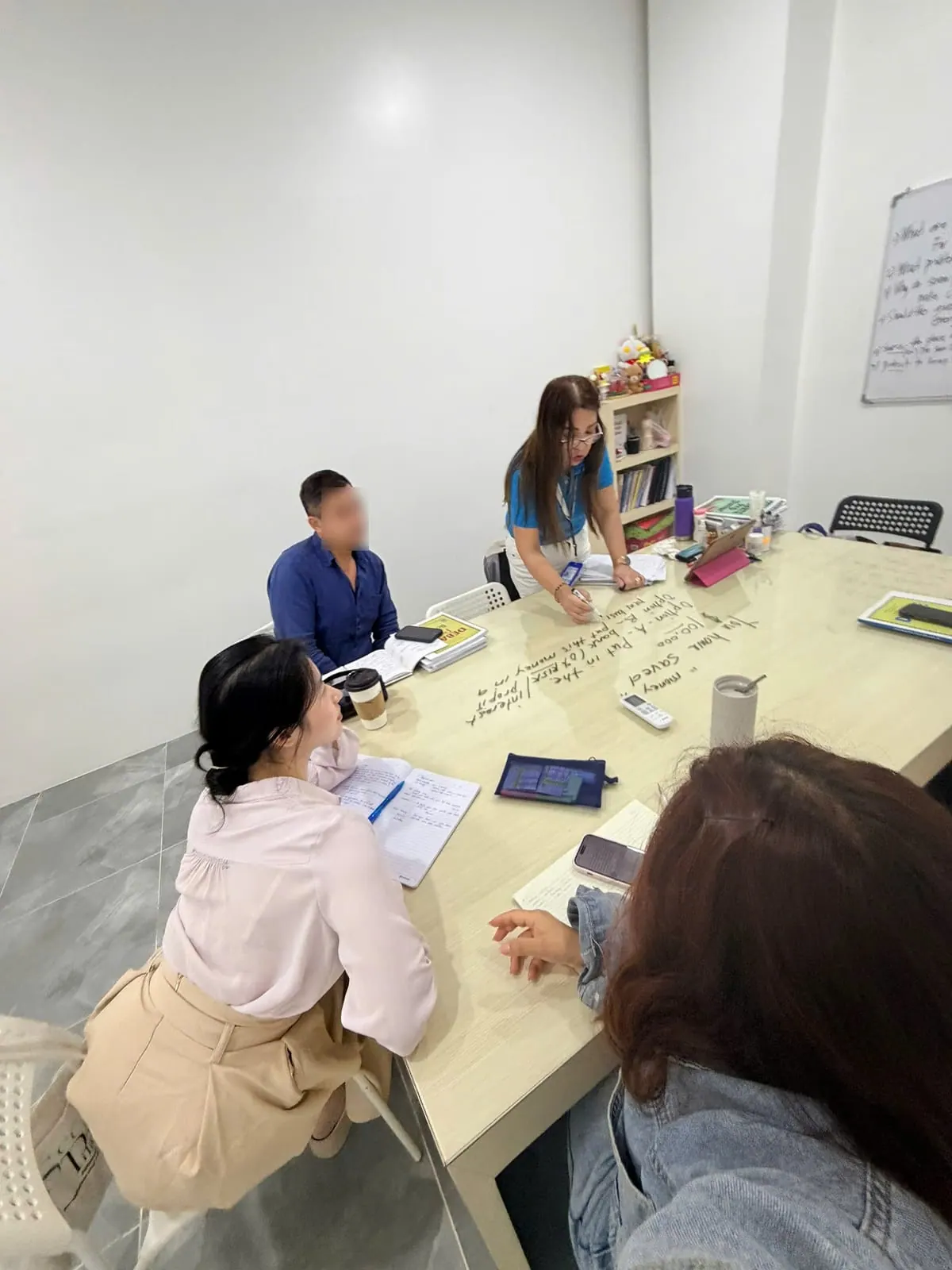 유리 테이블을 둘러싼 그룹 수업, 선생님이 테이블 위에 직접 판서