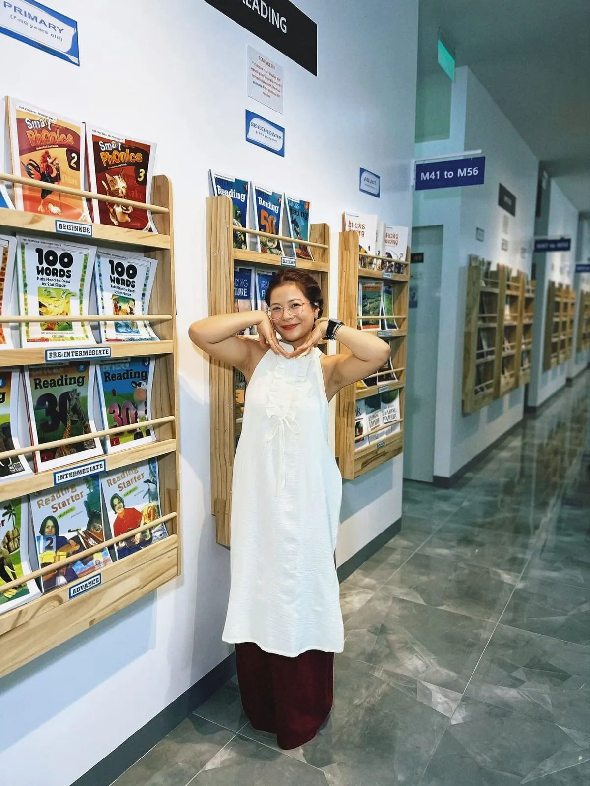 학원 복도의 교재 서가 옆에 선 투타오